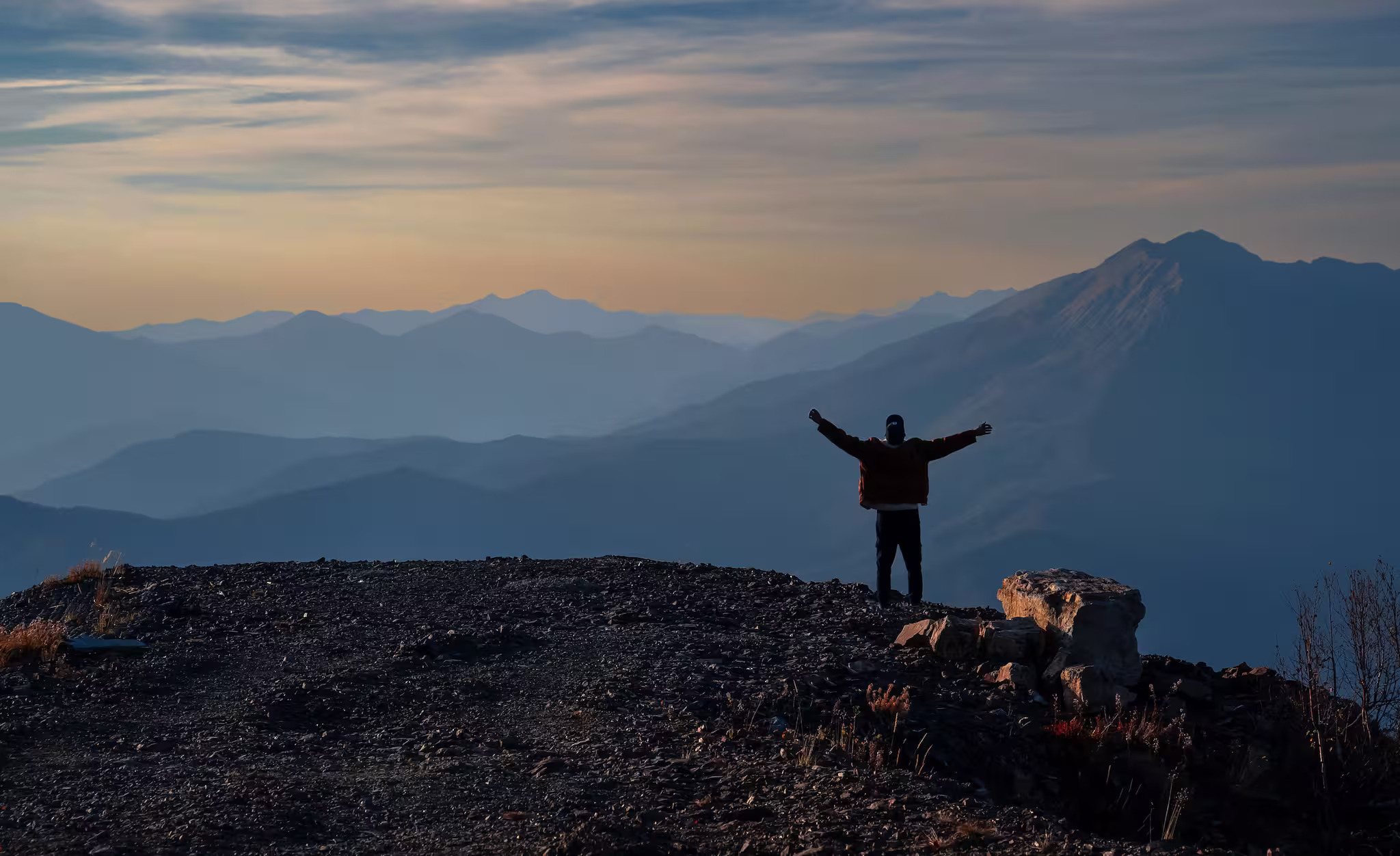 Persona de pie en la cima de una montaña